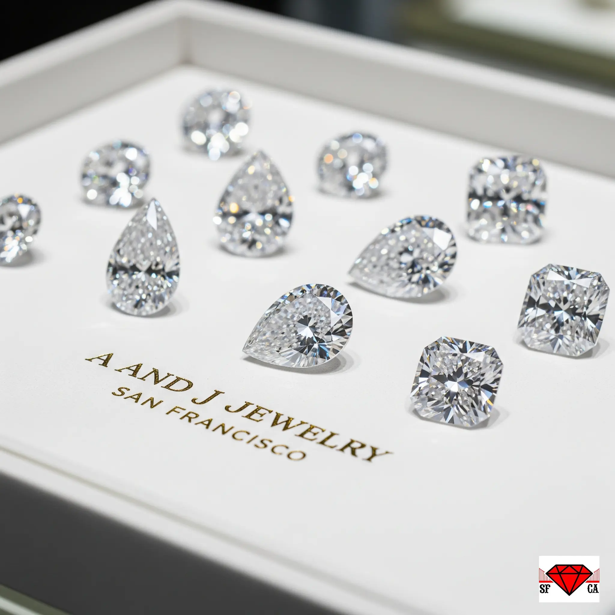 Loose GIA certified diamonds selection San Francisco - A and J Jewelry wholesale diamond display featuring round, pear, and cushion cuts on a professional jeweler tray